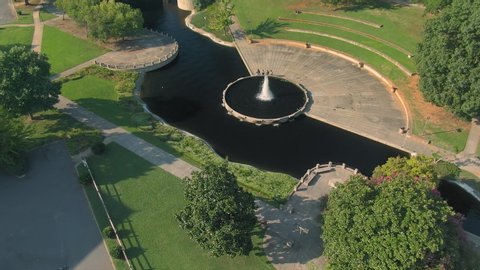 Aerial: flying over pond & fountain in Marshall Park in downtown Charlotte. North Carolina, USA. 