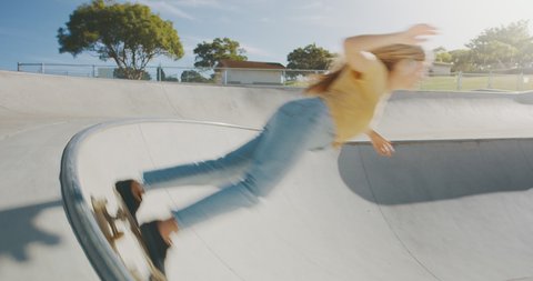 Stylish skater girl concept, young woman riding her skateboard around a concrete bowl in the morning, surf skate lifestyle