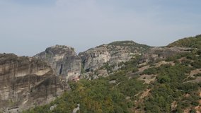 Meteora rocks and monastery complex occupied by tourists 4K tilting video