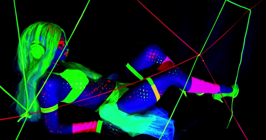Young female dancer is glowing in uv light, lifting her leg up, colorful, 4...