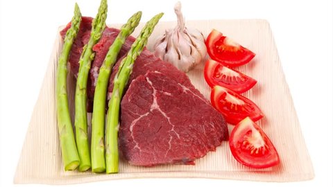 fresh raw beef meat steak fillet on wooden plate with asparagus and tomatoes ready to prepare 1920x1080 intro motion slow hidef hd