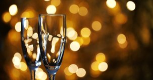 Champagne is poured into glasses against the background of New Year 's garland.