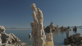 Panning shot of tufa rock formations at lake / Mono Lake, California, United States