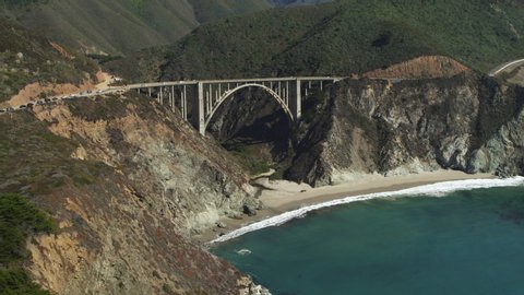 Aerial view of bridge at rocky coast near ocean waves / Big Sur, California, United States