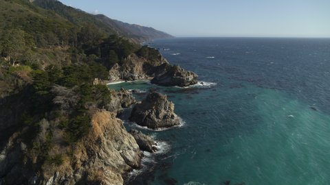 Aerial view of ocean waves on rocks in cove / Big Sur, California, United States