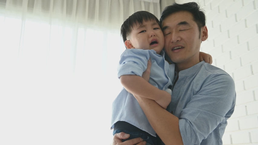 Parents came to comfort half-Japanese boy after slipped and his head hit by floor until he cried. Happy family and baby of Multi-ethnics mixed race people concept. Appreciate parenthood and child Royalty-Free Stock Footage #1042331443