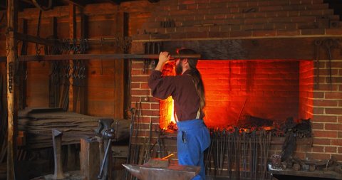 Mount Vernon, Virginia / USA - November 13, 2019: Old Fashioned Blacksmith in Shop, Historical Reenactment, Slow Motion