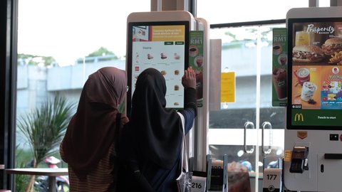 Seremban, Malaysia - 5/12/2019 : People using the self-ordering kiosk to order and pay at a McDonald's store in Sereman Gateway