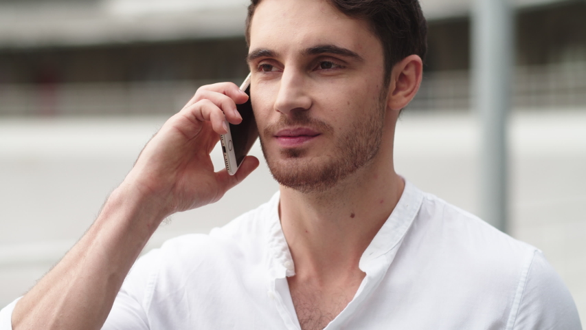 Close up of happy businessman having talk on mobile phone outside. Portrait of handsome business man call phone outdoor. Young manager talking phone outdoor.