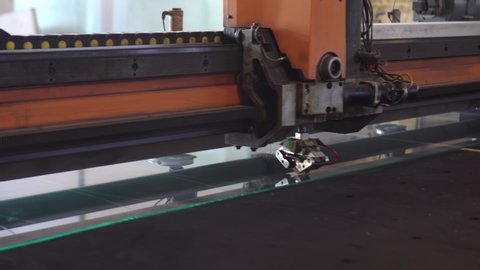 Automatic machinery is cutting the glass