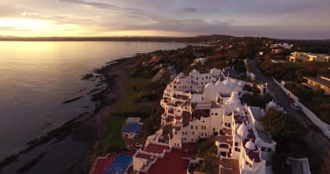 Oct 2016. Panoramic view over an unusual hotel located close to the famous Uruguayan resort of Punta del Este. Picturesque seascape and coastline around. Beautiful sunset light and calm ocean water.