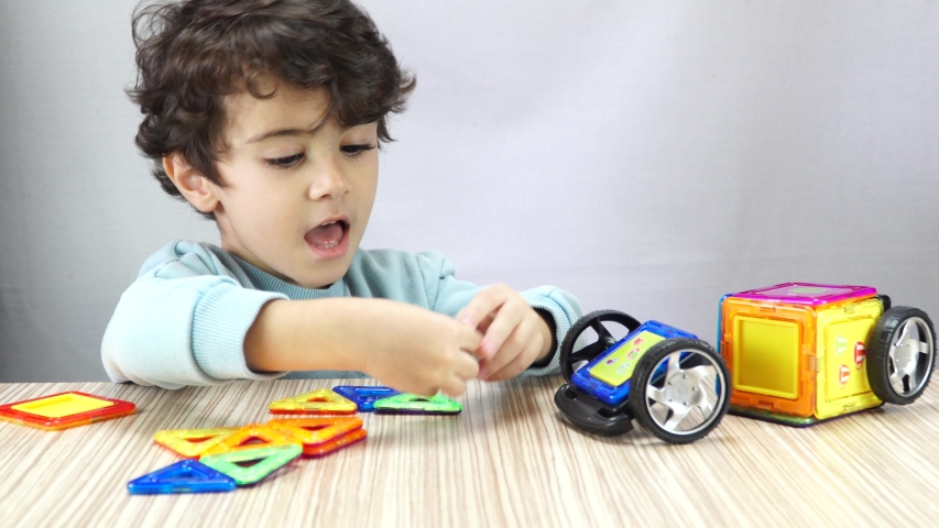 Child playing with colorful magnetic cube toy. 4K