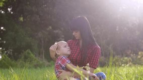 happy family mom and son concept . mom tender childhood a video . slow motion video . mom brunette girl gently hugs takes care of the boy son blonde lifestyle outdoors