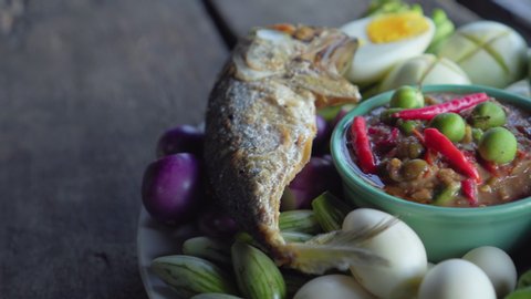 Set plate of fried mackerel with shrimp paste sauce and vegetables. Thai dish. pan shot. close up. 4K