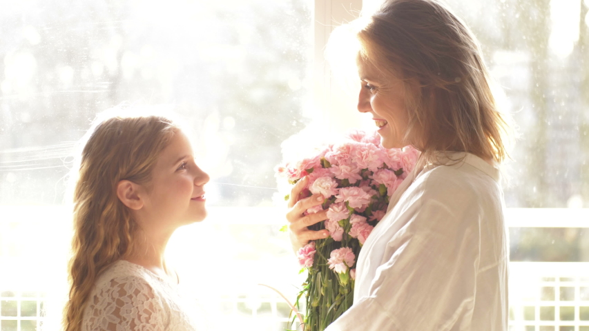 Child daughter congratulates moms and gives her a gift box. Happy mother's day
