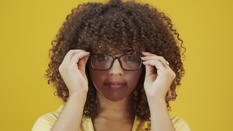 Young woman with curly hair happy with her glasses. Eye care concept. 