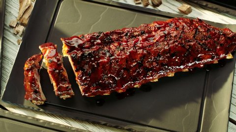 white smoke clouds reveal barbecued ribs presented on slate platter
