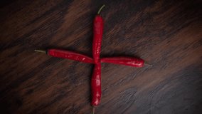 Stop motion food video with chili pepper on wooden background.Spicy hot peppers animation on a table move in a circle. Vegetables, food, hot, hot, pepper