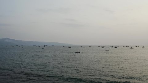 Many small ships seen out at sea from beach, Indonesia, Panning right