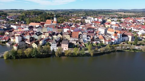 Scenic view from drone of historic center of Czech town of Jindrichuv Hradec on banks of Nezarka river with Renaissance castle and church belfry on autumn day