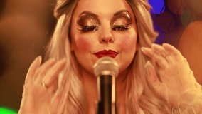 Video clip young woman singer in a New Year’s costume Snow Maiden sings a song in stage light - Powered by Shutterstock - Get 15% off with code: PIKWIZARD15