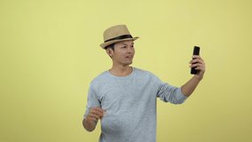Asian Thai live streaming video on social media with smart phone on yellow background
