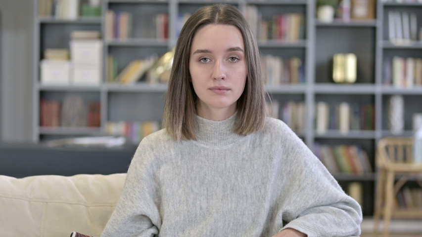 Portrait of Young Woman saying No by Shaking Head