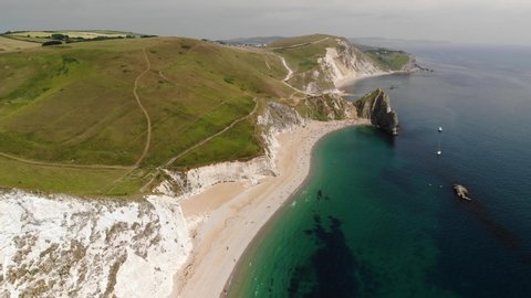 Aerial Drone Shot of Distant Durdle Door Natural Limestone Arch, Jurassic Coast, Dorset, UK
