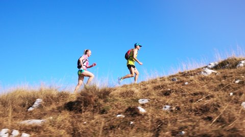 Slow motion shot of two joggers running on a hill