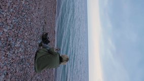 Girl on the beach, video call on smartphone, autumn, vertical video footage