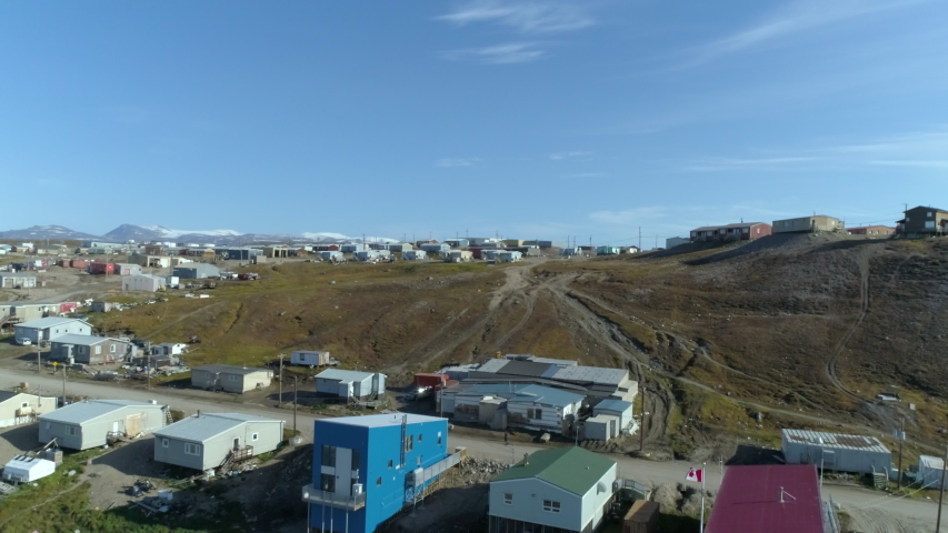 Drone, aerial, wide shot of homes and trailers on hilly ground.