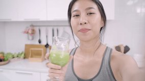 Asian blogger lady make vlog how to diet and lost weight, Young indian female using smartphone recording when she drinking apple juice in the kitchen. Lifestyle influencer women healthy food concept.
