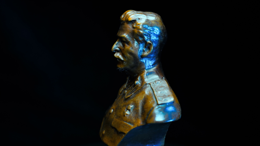 Bronze bust of the head of the Soviet state Joseph Stalin rotates on a black background. Macro. Closeup