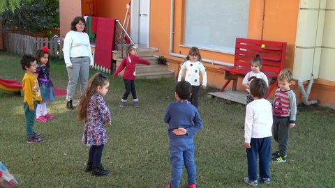 Fethiye, Turkey - 27th of November 2019: 4K At the Istanbul Development nursery school - Children with their teacher do morning exercises outdoors
