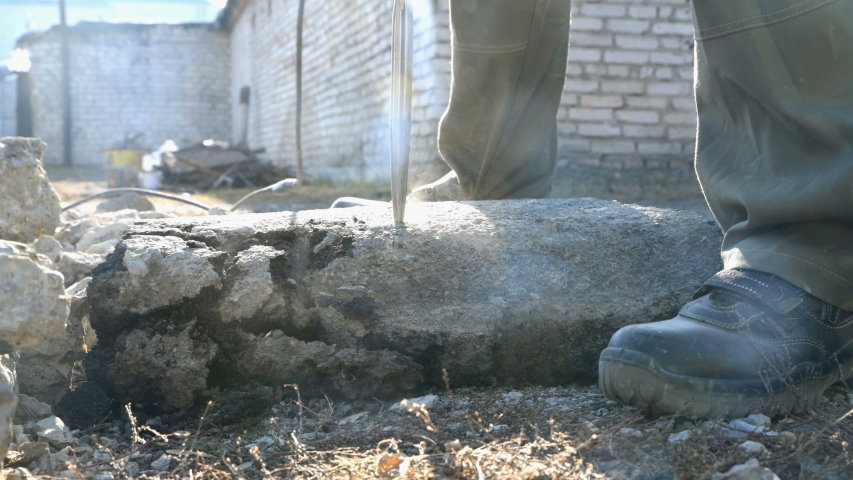 Crushing asphalt from the road to small stones with a jackhammer