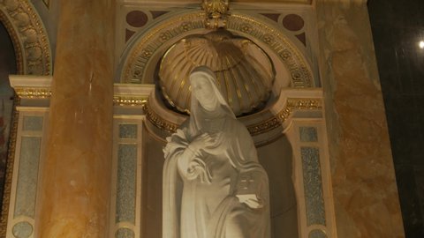 Budapest, Hungary - 10 28 2019: Catholic saint statue in temple female woman Bible in hands St. Stephen's Basilica in Budapest Hungary Roman Catholic church