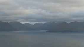 Evening timelapse with moving clouds and blue mountain peaks in the summer Faroe Islands, Denmark. UHD 4k video