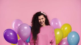 happy girl holding balloons isolated on pink