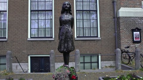 Amsterdam, Netherlands-13 May, 2019: 4K, Anne Frank statue memorial on Westerkerk Plaza near to her house and the holocaust museum in Holland. A popular tourist destination.