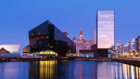Liverpool, UK. Skyline of Liverpool, England, UK during the sunrise. Time-lapse of modern buildings with car traffic and reflection in the water
