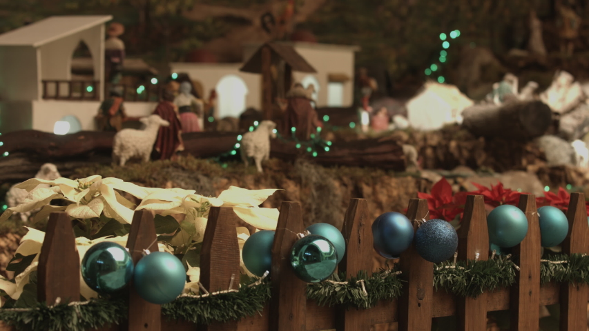 Holy family, shepherds in Nativity scene. Christmas manger with figures and atmospheric lights. 
