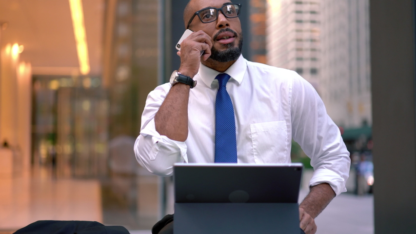 Dark skinned Latin trader in classic eyewear talking with corporate colleague receiving good news about approved financial project and business plan for it, African American man making roaming call
 Royalty-Free Stock Footage #1042495576