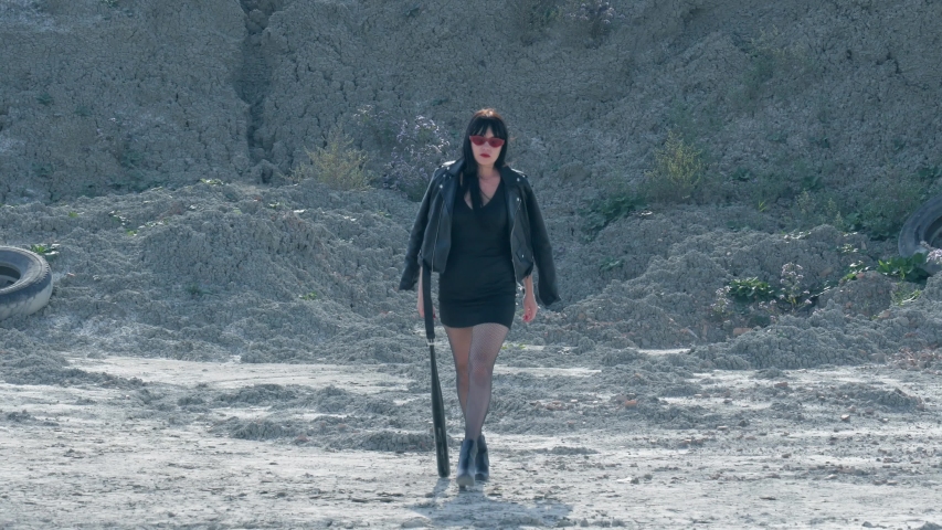 Sexy hipster girl, walking through the wasteland, in a black leather jacket,