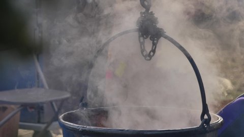 Dipping label into steaming cauldron outside fall