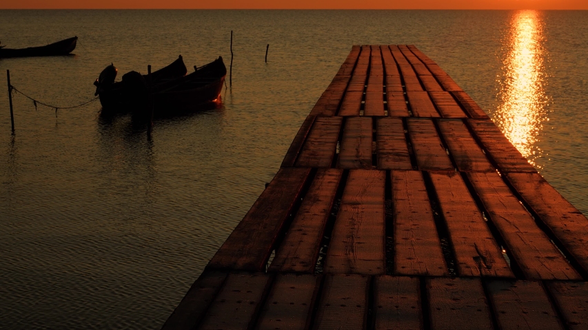 beautiful sunset over water and silhouette of fishing boat