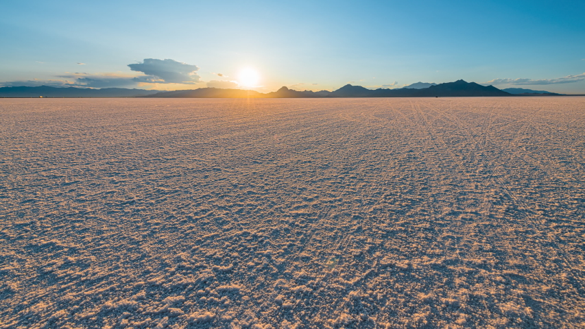 Time lapse timelapse of Bonneville Salt Flats blue orange colorful landscape sunset near Salt Lake City, Utah and silhouette view of mountain, sun setting behind clouds