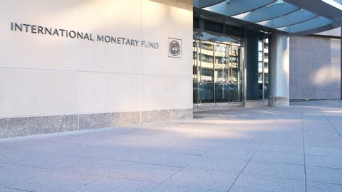 Washington DC, USA - March 9, 2018: Loopable cinemagraph of IMF entrance with sign of International Monetary Fund, logo, sidewalk, security guard hiding behind wall