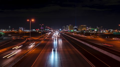 Night timelapse of highway traffic on I-15 and Las Vegas Strip casinos skyline