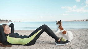 Young adult sporty woman training with little dog outdoor