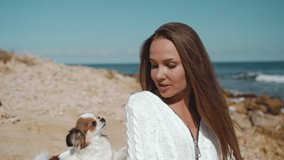Young adult girl spending day on beach with little dog